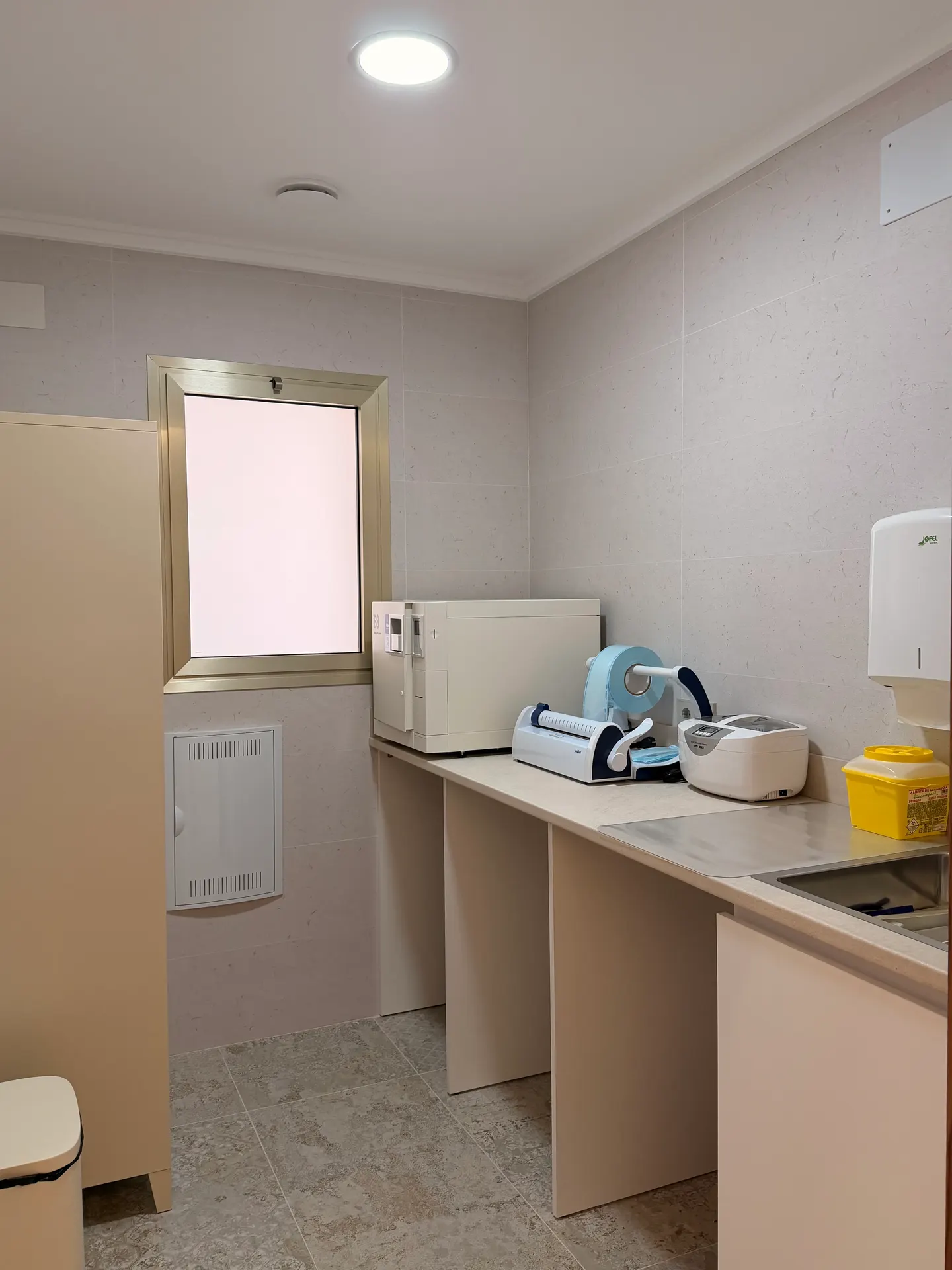 Sala de esterilización, con autoclave, selladora de bolsas y encimera de trabajo